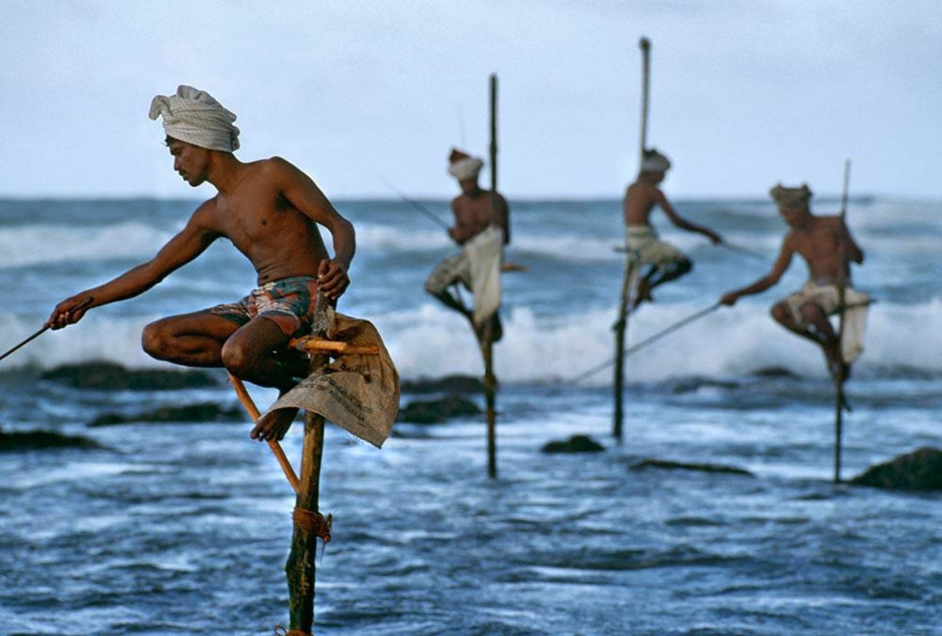 Traditional stilt fishermen at sunset near Weligama